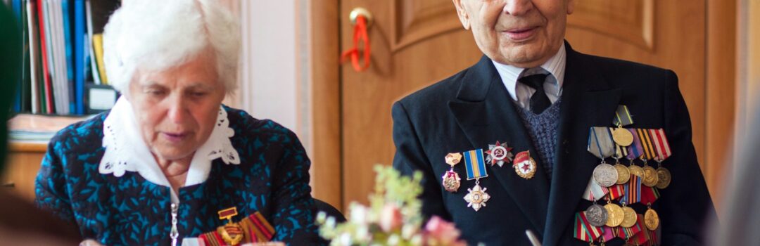 Veteran sitting at a table with his wife, enjoying their home financed through a VA rates home loan.